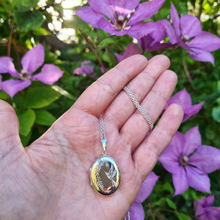 locket necklace in hand for scale