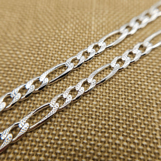 close up of diamond cut pattern on figaro chain