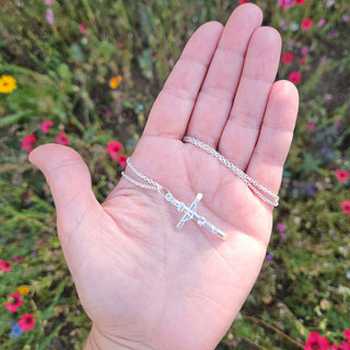 silver crucifix in hand for scale