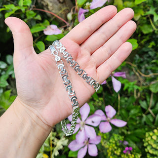 chunky silver byzantine chain in hand for scale