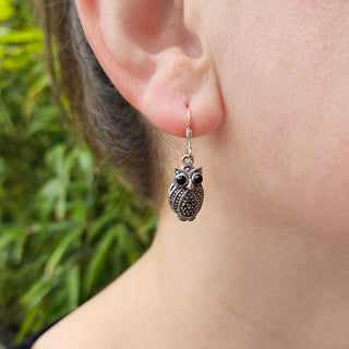 owl dangle earrings in ladies ear