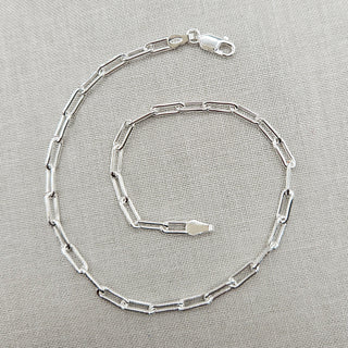 A solid silver ankle bracelet made from a paperclip chain