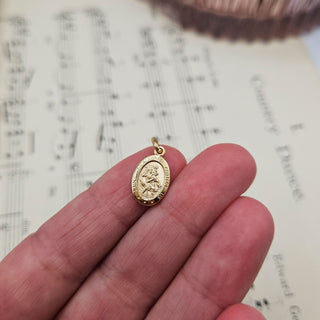 st christopher charm in hand for scale