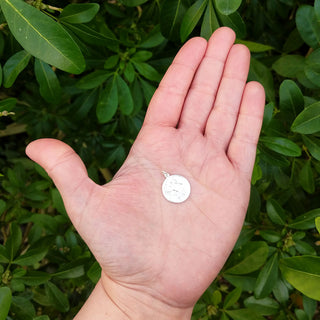 st christopher pendant in hand for scale