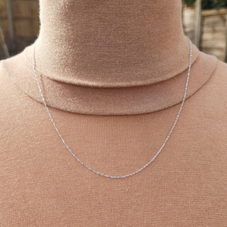 dainty white gold chain on neck
