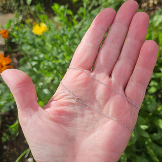 delicate and sparkly white gold chain in hand
