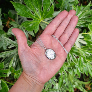 celtic locket pendant in hand for scale