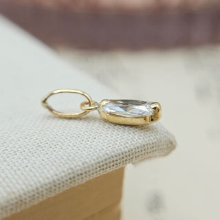 side profile of tiny baguette charm in gold