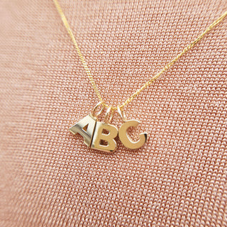 initial pendants hanging from gold chain