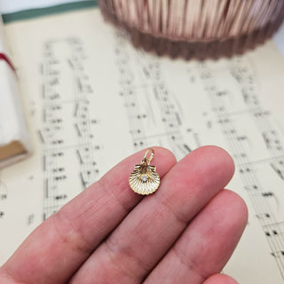 real gold shell charm in hand for scale