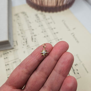 gold star charm in hand for scale
