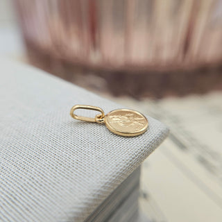 side profile of tiny gold christopher pendant