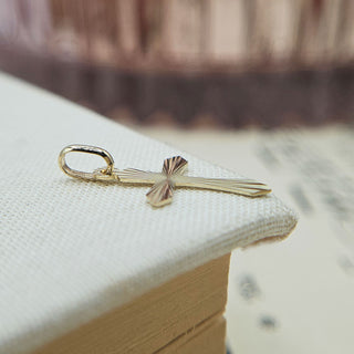 flared gold cross charm pointed ends starburst pattern