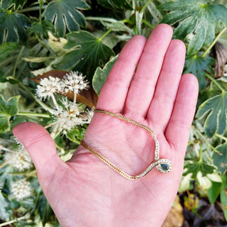 view of emerald choker necklace in hand