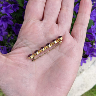 amethyst brooch in hand for scale