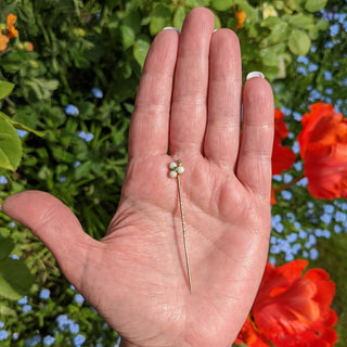 antique lapel pin in hand for scale