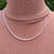 silver belcher chain on man's neck