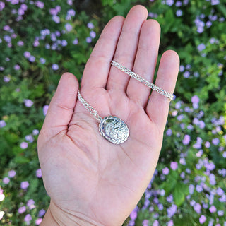 necklace in hand for scale