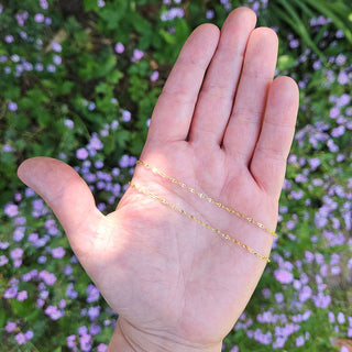 gold anchor chain in hand for scale