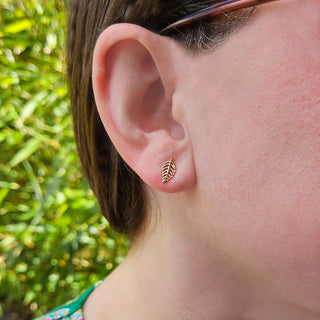 yellow gold leaf studs in ladies ear