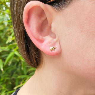 solid gold elephant earrings being worn by an adult female