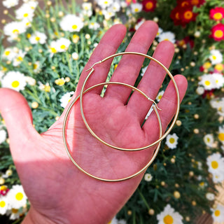 giant hoop earrings in hand for scale