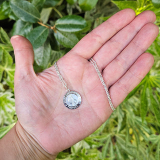 st christopher pendant in hand for scale