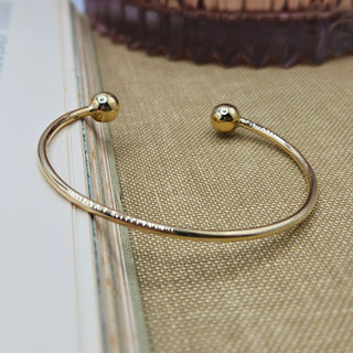 women's solid gold bangle with ball ends