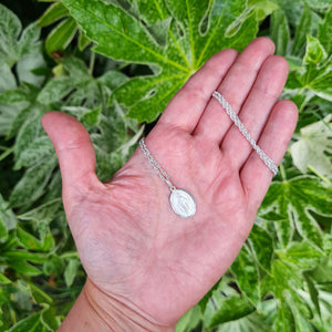 miraculous pendant in hand for scale