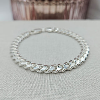 close up of cuban curb links on silver chain bracelet