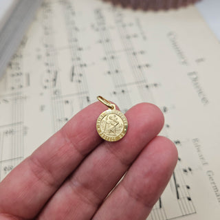 gold st christopher in hand for scale