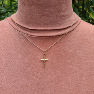 gold cross  necklace being worn