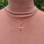 gold cross  necklace being worn