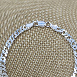 close up of curb links and lobster clasp on chain bracelet