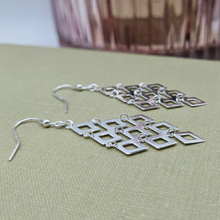 side profile of sleek and slink silver drop dangle earrings