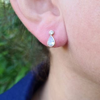 gold pear drop earrings in ear