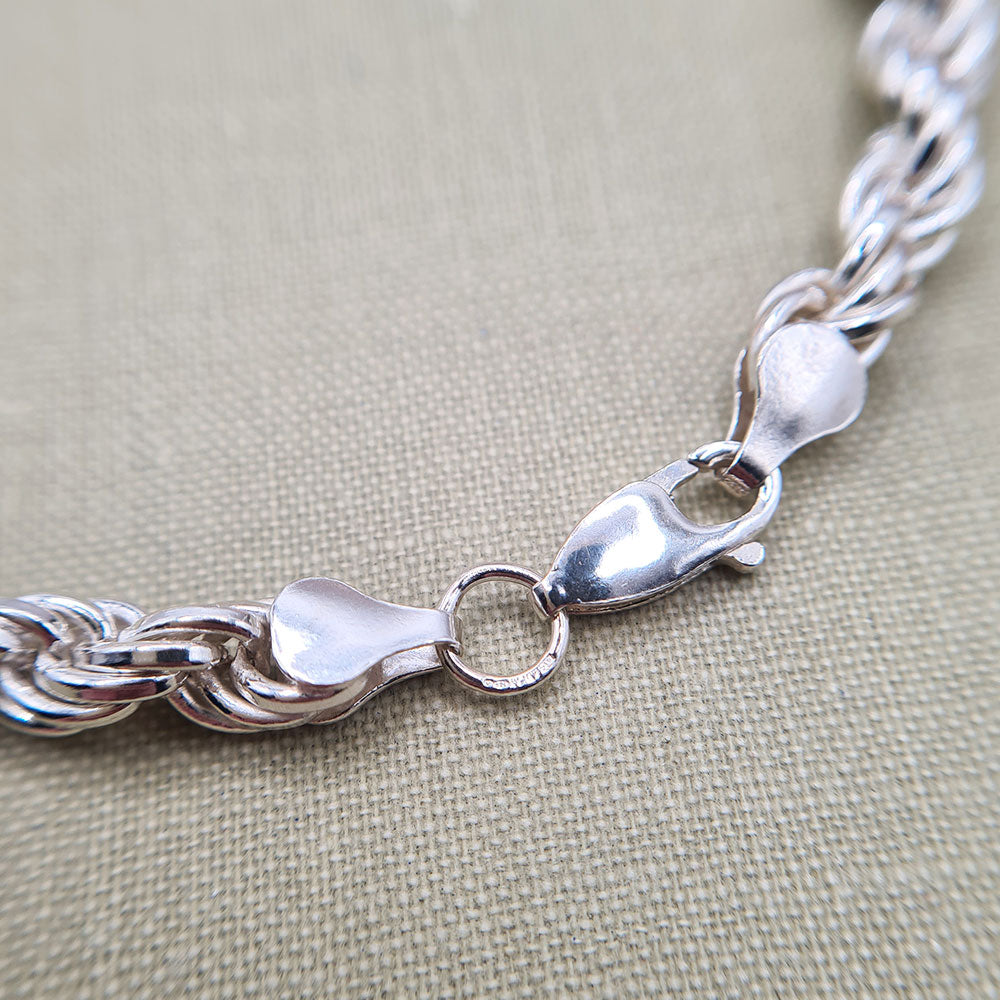 close up of lobster clasp and hallmark on men's silver bracelet