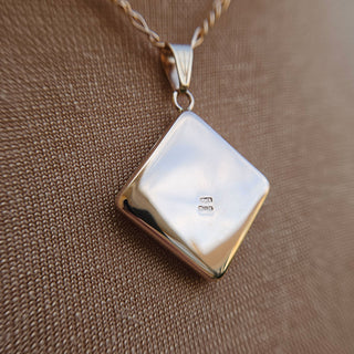 plain, polished, hallmarked reverse of rose gold locket