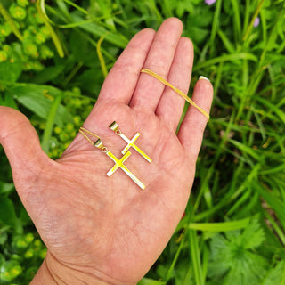 women's 9K gold cross necklace in hand