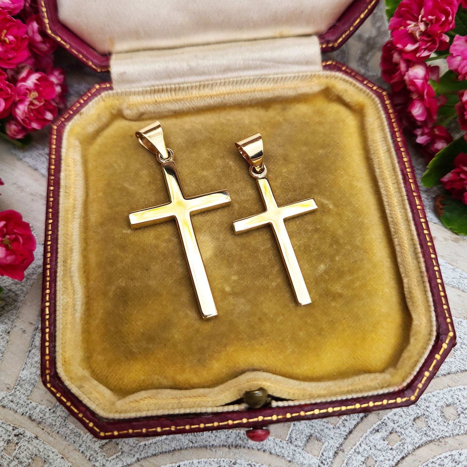 small and medium solid gold crosses side by side