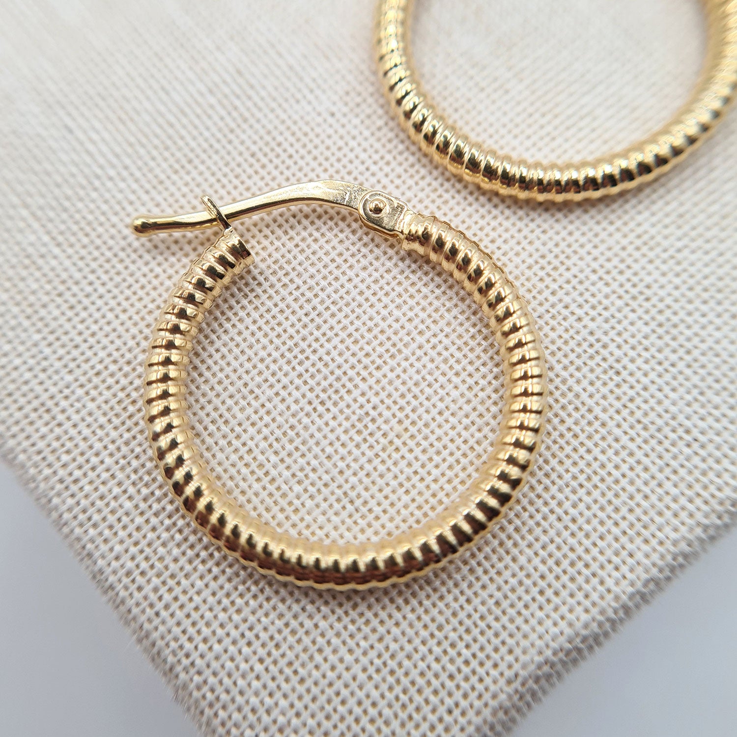 close up of yellow gold hoop earrings