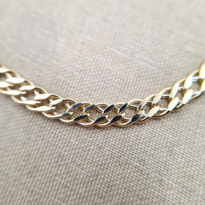 close up on double curb links on women's gold bracelet