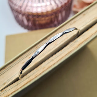 close up of faceted wire on ladies silver bangle