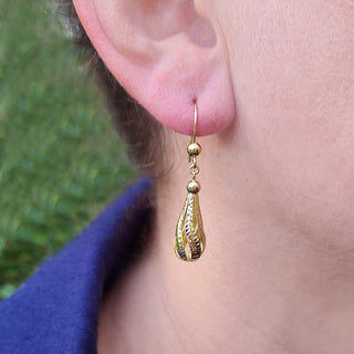 gold teardrop dangle earrings in ear