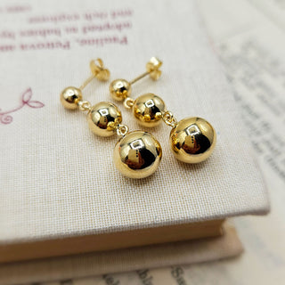 close up of ball earrings in 9K yellow gold