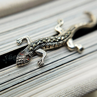 close up of red glass eyes on lizard brooch