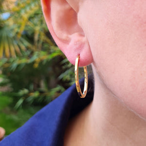 gold oval hoops being worn