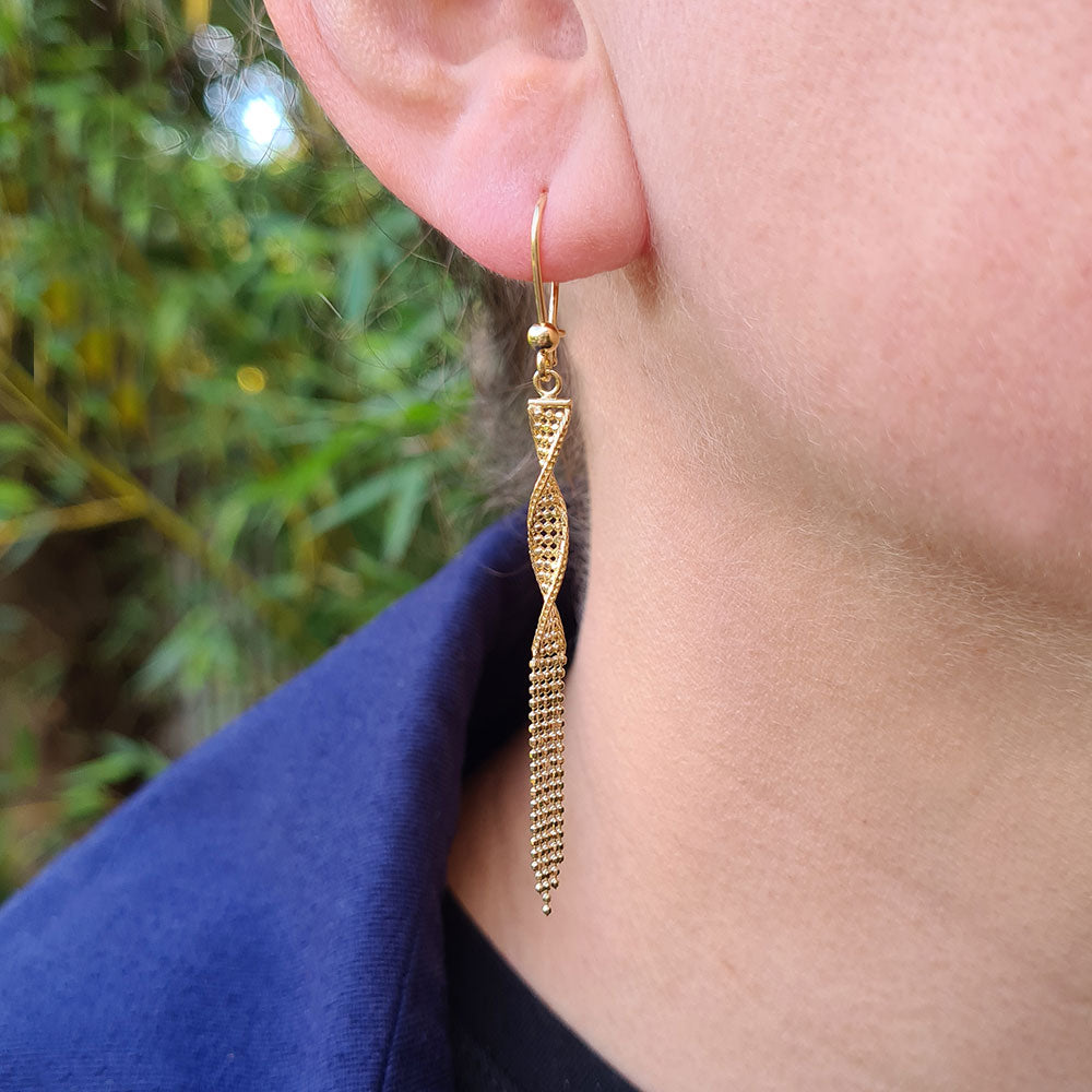 gold tassel drop earring in ear