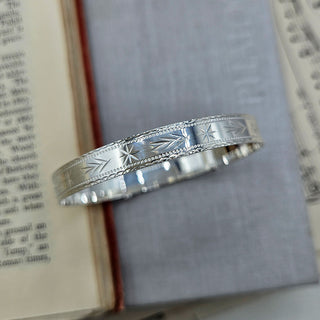 close up of dianond cut pattern on ladies silver bangle