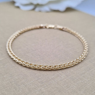 Close up view of gold spiga links on ladies bracelet